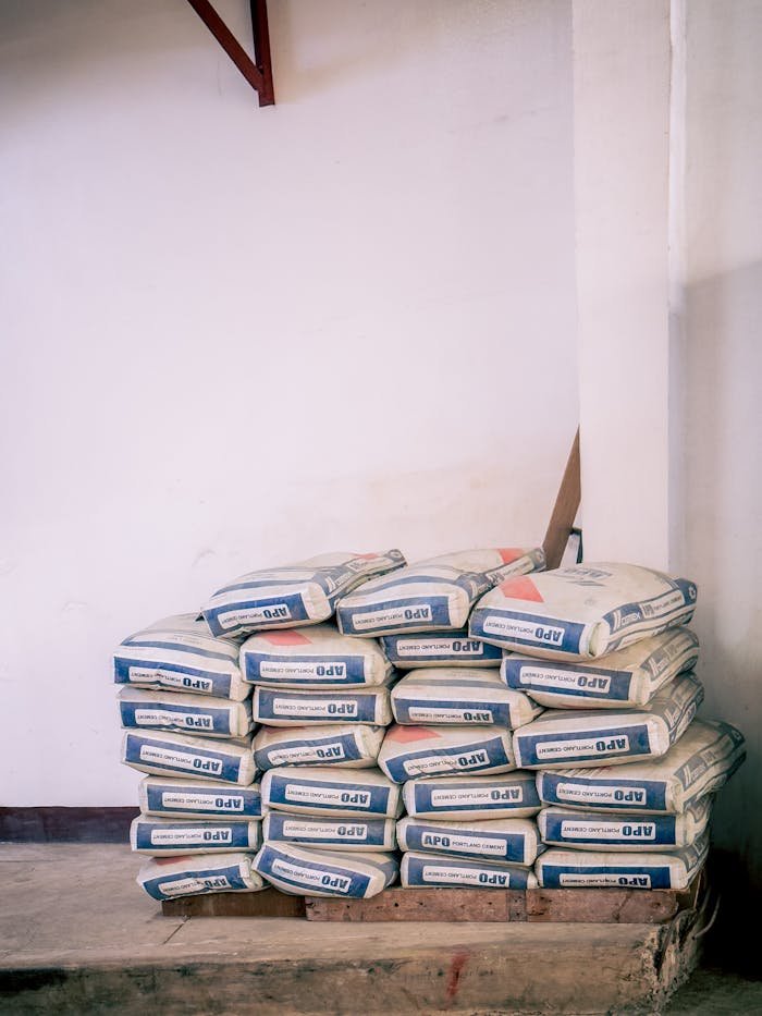 digital A stack of bags of cement neatly arranged in an indoor warehouse environment.