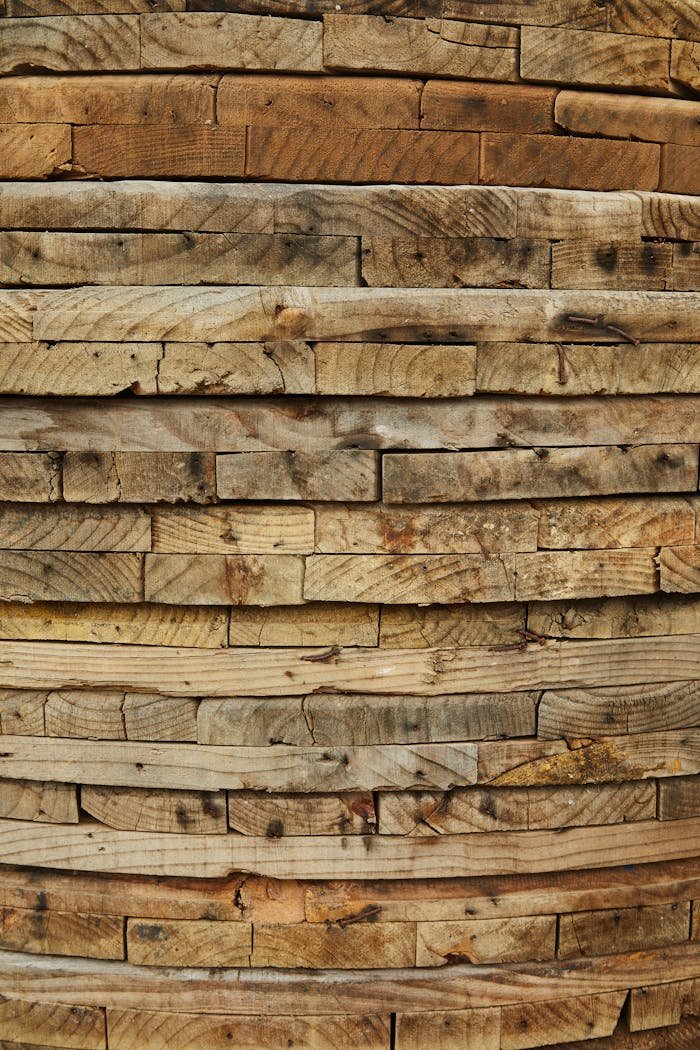 why-choose-us A close-up of stacked wooden planks showcasing natural wood grain and texture.